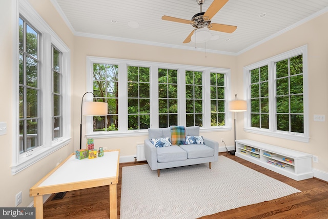 sunroom with wood finished floors, baseboards, and crown molding