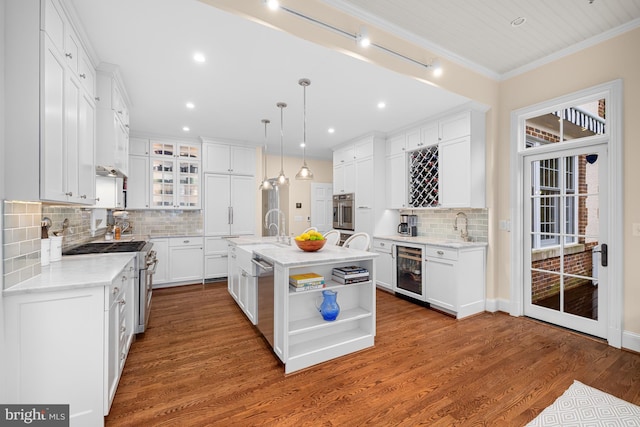 kitchen featuring appliances with stainless steel finishes, beverage cooler, backsplash, white cabinets, and crown molding