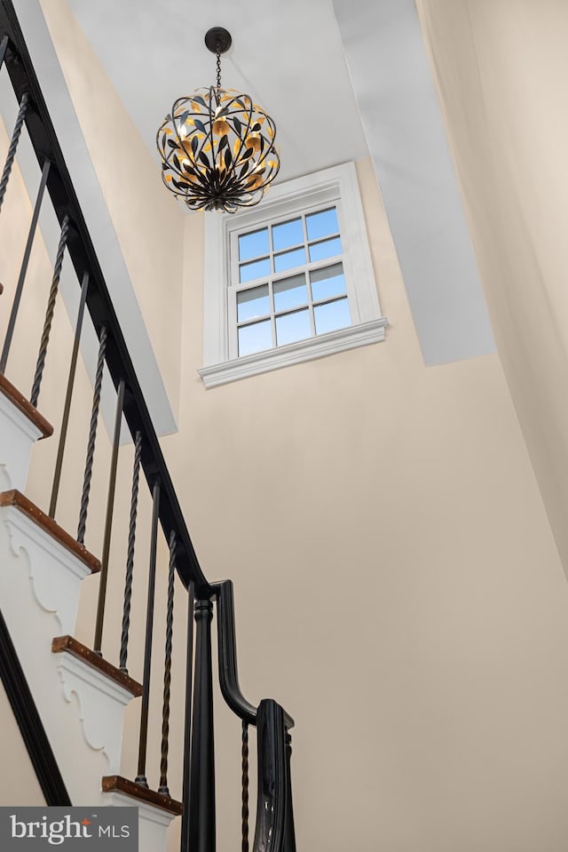 stairs with a chandelier