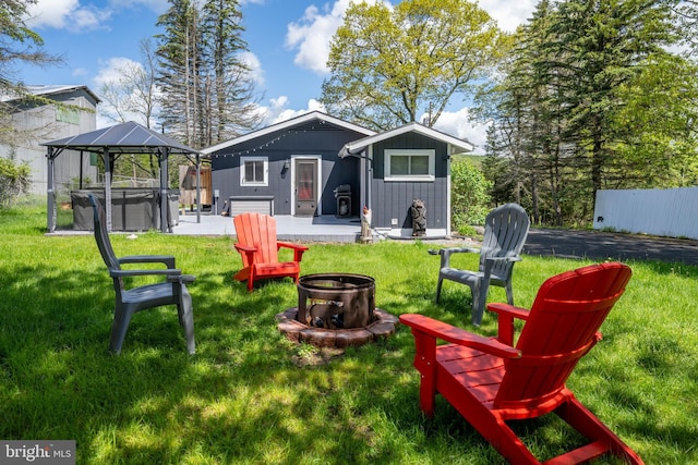 3432 Glendale Rd, Swanton, MD 21561 - rear view of property featuring a hot tub, board and batten siding, an outdoor fire pit, a yard, and a patio area