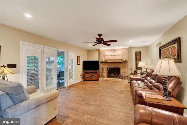 living area with light wood-style floors, ceiling fan, recessed lighting, a fireplace, and baseboards