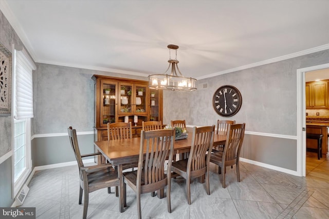 dining area with a chandelier, ornamental molding, and baseboards