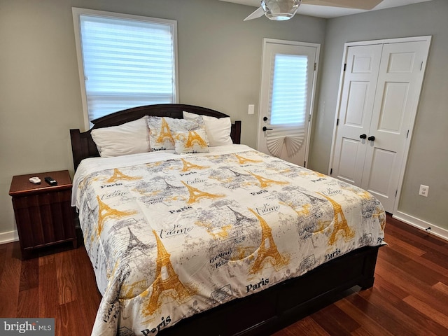 bedroom featuring baseboards, dark wood-style flooring, and a closet