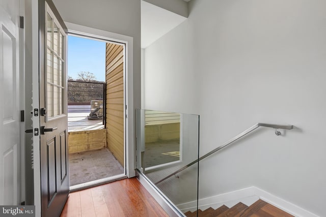 staircase featuring wood finished floors and baseboards