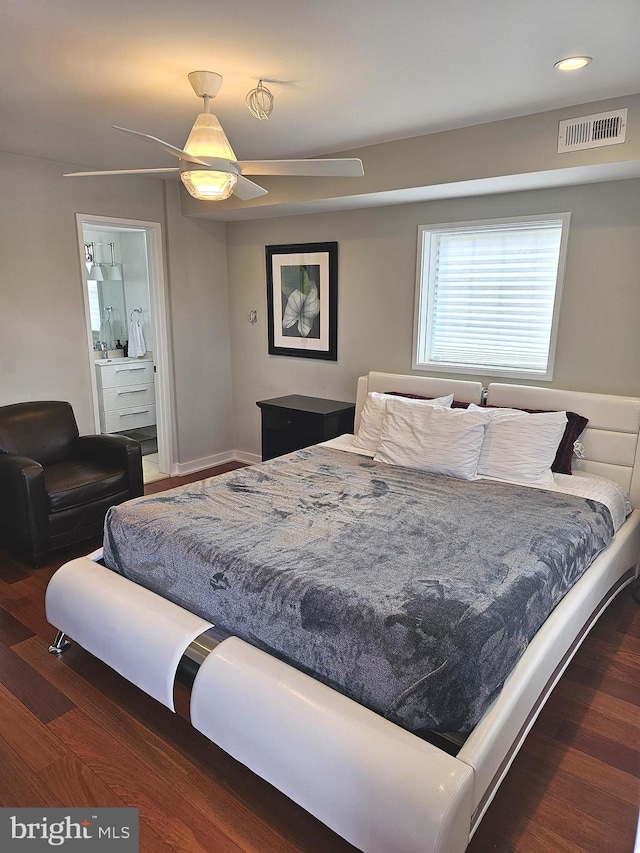 bedroom with wood finished floors, ensuite bathroom, and recessed lighting
