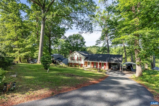 186 Sunset Dr, Stanardsville, VA 22973 - tri-level home featuring a carport, driveway, a front yard, a chimney, and view of wooded area