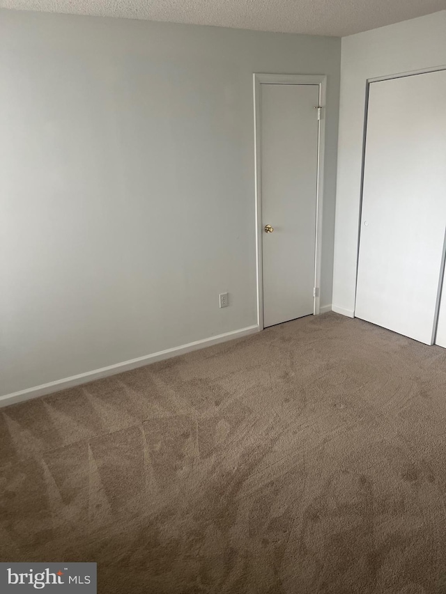 unfurnished bedroom featuring carpet floors and baseboards