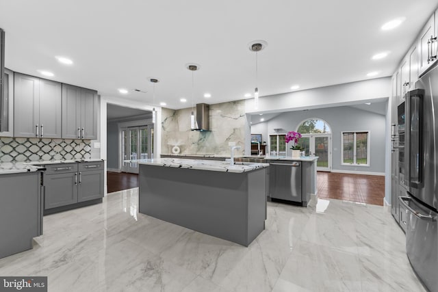616 Webb Rd, Elkins Park, PA 19027 - kitchen featuring stainless steel appliances, gray cabinetry, wall chimney exhaust hood, backsplash, and an island with sink