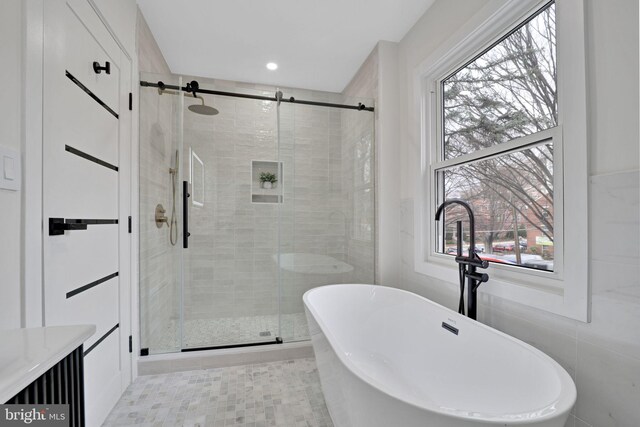 8120 Eastern Ave NW, Washington, DC 20012 - full bathroom featuring a stall shower, a soaking tub, healthy amount of natural light, and tile walls