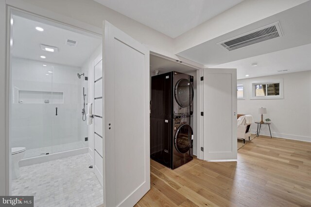 8120 Eastern Ave NW, Washington, DC 20012 - laundry room featuring stacked washer and clothes dryer, light wood-style flooring, recessed lighting, and baseboards