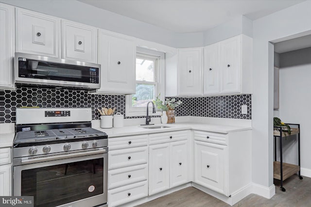 1711 Langley Rd, Baltimore, MD 21221 - kitchen featuring stainless steel appliances, a sink, light countertops, white cabinetry, and light wood-type flooring