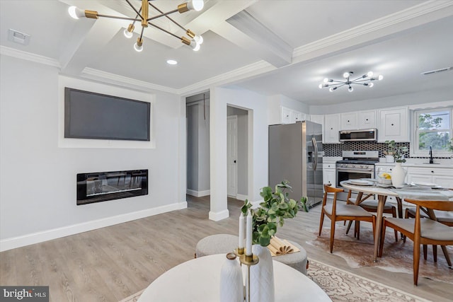 1711 Langley Rd, Baltimore, MD 21221 - kitchen with stainless steel appliances, a chandelier, beamed ceiling, white cabinets, and light wood finished floors