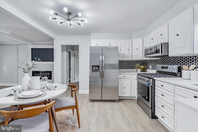 1711 Langley Rd, Baltimore, MD 21221 - kitchen with stainless steel appliances, light countertops, white cabinets, and tasteful backsplash