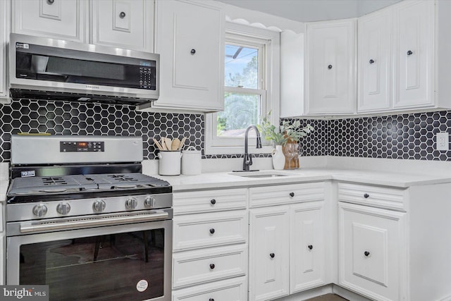 1711 Langley Rd, Baltimore, MD 21221 - kitchen with appliances with stainless steel finishes, a sink, white cabinets, and tasteful backsplash