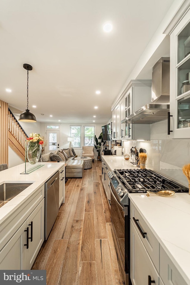 1919 Bennett Pl NE, Washington, DC 20002 - kitchen with stainless steel dishwasher, range with gas cooktop, wall chimney range hood, light wood-style flooring, and recessed lighting