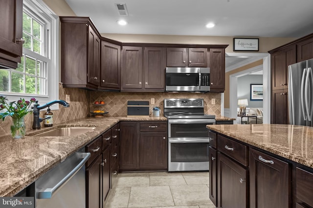 121 Beech Dr, Hatboro, PA 19040 - kitchen with stainless steel appliances, a sink, dark brown cabinets, tasteful backsplash, and light stone counters
