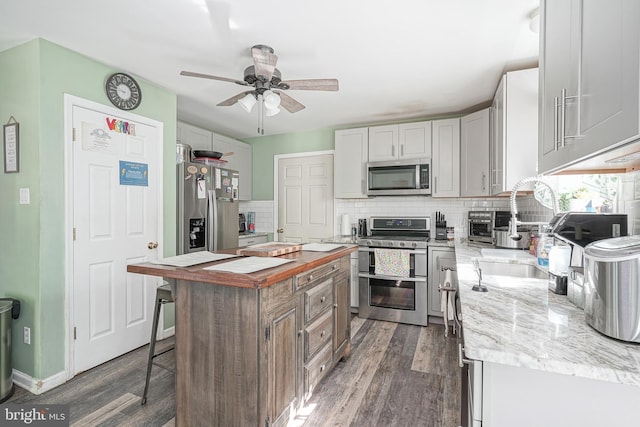 33 Laurel Rd, Millville, NJ 08332 - kitchen with appliances with stainless steel finishes, backsplash, dark wood-style floors, and light stone countertops