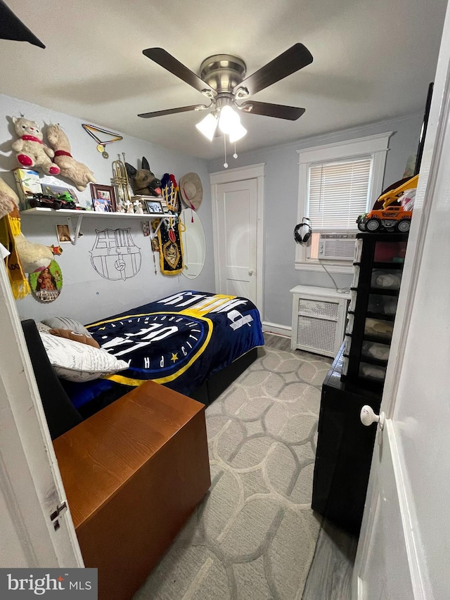 bedroom with radiator heating unit, a ceiling fan, and cooling unit