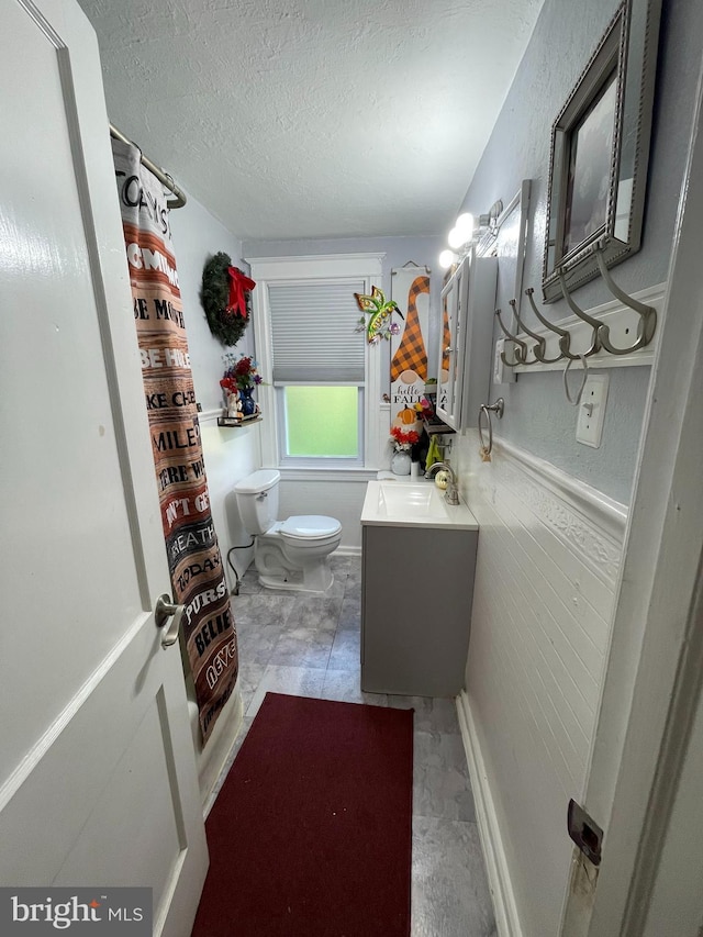full bath with toilet, a textured ceiling, vanity, and a shower with shower curtain