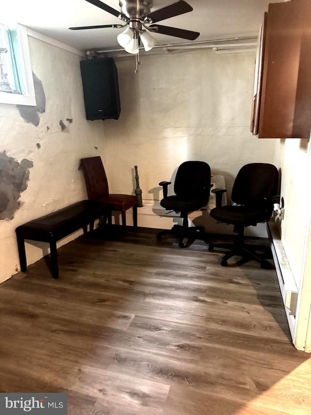 living area with wood finished floors and a ceiling fan