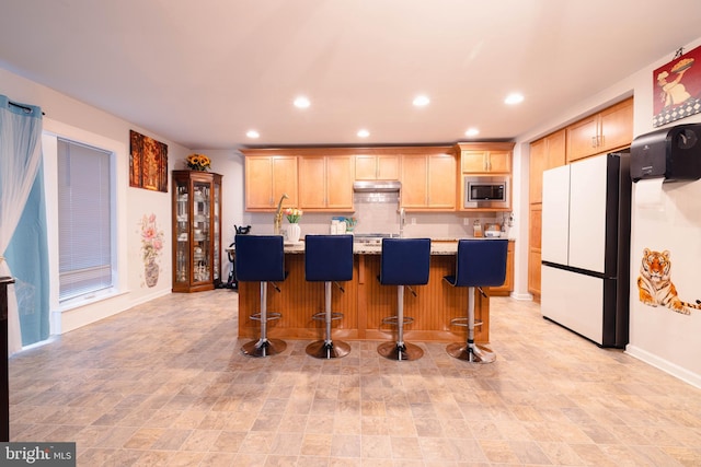 1722 Bradley Dr, Harrisburg, PA 17110 - kitchen with freestanding refrigerator, stainless steel microwave, light brown cabinets, recessed lighting, and a kitchen island