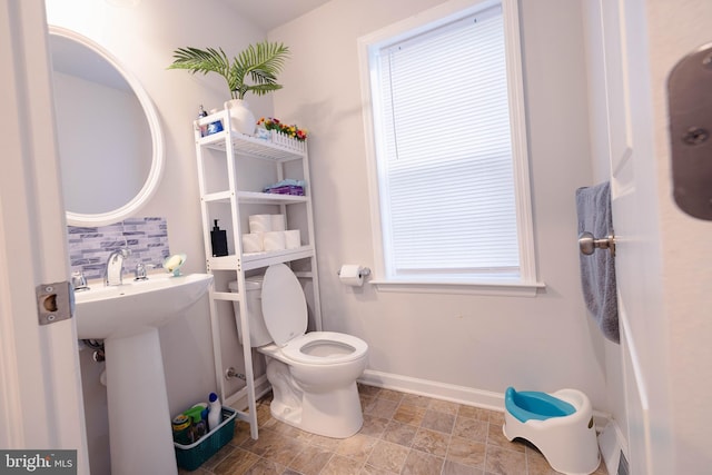 1722 Bradley Dr, Harrisburg, PA 17110 - bathroom with backsplash, toilet, baseboards, and stone finish floors