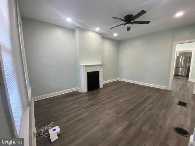 unfurnished living room with a ceiling fan, dark wood finished floors, a fireplace, baseboards, and recessed lighting