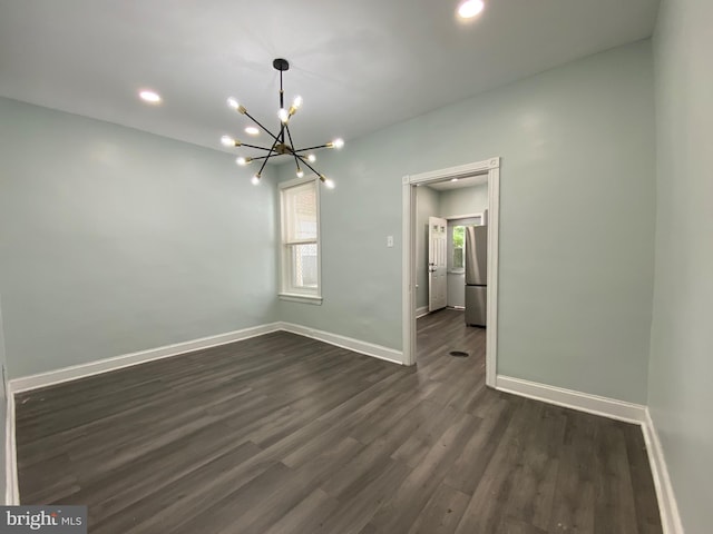 unfurnished room featuring a chandelier, dark wood finished floors, baseboards, and recessed lighting
