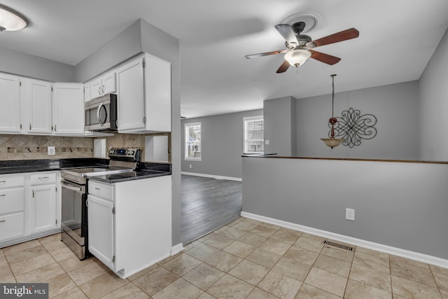 1223 Kendrick Rd, Baltimore, MD 21237 - kitchen with appliances with stainless steel finishes, a ceiling fan, white cabinets, decorative backsplash, and baseboards