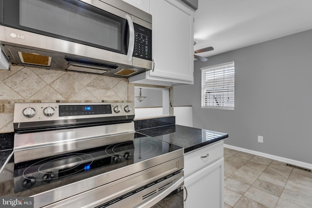 1223 Kendrick Rd, Baltimore, MD 21237 - kitchen with stainless steel appliances, decorative backsplash, dark countertops, white cabinetry, and a ceiling fan