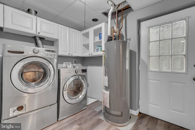 1223 Kendrick Rd, Baltimore, MD 21237 - laundry area featuring cabinet space, washing machine and dryer, water heater, and light wood-style flooring