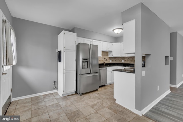 1223 Kendrick Rd, Baltimore, MD 21237 - kitchen featuring appliances with stainless steel finishes, dark countertops, white cabinetry, baseboards, and decorative backsplash