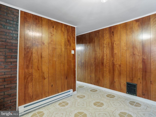 unfurnished room featuring a baseboard heating unit and wood walls