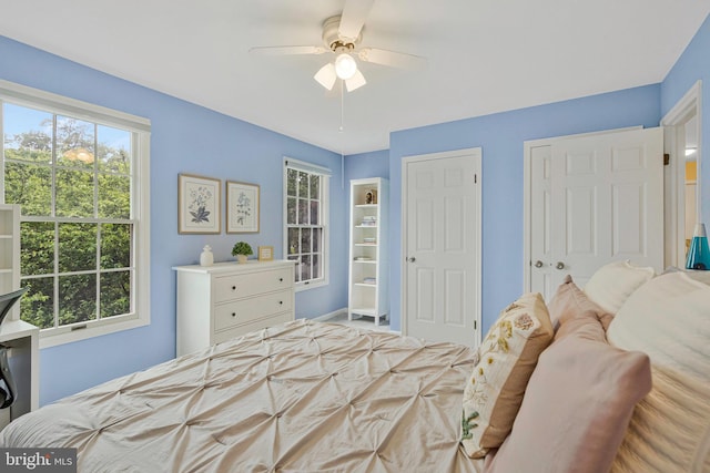 12641 Terrymill Dr, Herndon, VA 20170 - bedroom with multiple windows, a ceiling fan, and baseboards