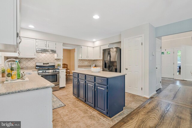 12641 Terrymill Dr, Herndon, VA 20170 - kitchen with gas stove, black fridge with ice dispenser, under cabinet range hood, white cabinetry, and decorative backsplash