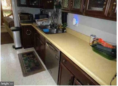 4098 Camelot, Dumfries, VA 22026 - kitchen with a sink, stainless steel dishwasher, dark brown cabinets, and light countertops