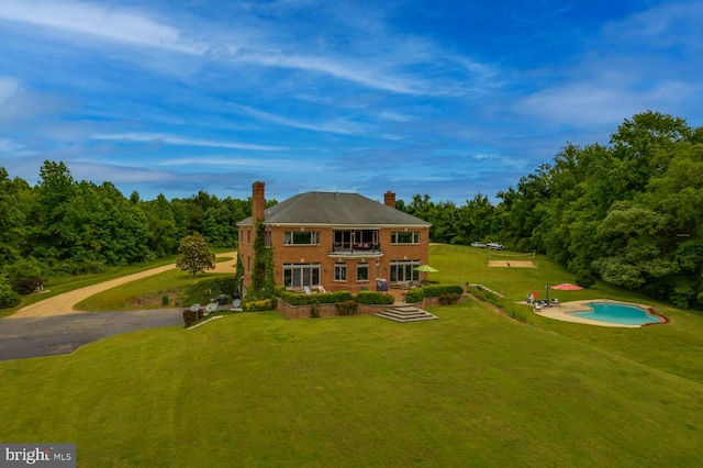 46369 Hattons Rest Ln, Lexington Park, MD 20653 - view of front of home featuring a chimney, a balcony, a front yard, brick siding, and a wooded view