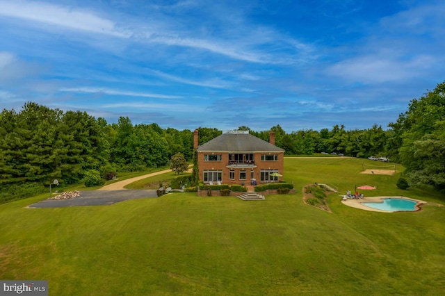 46369 Hattons Rest Ln, Lexington Park, MD 20653 - view of front of home featuring a balcony, a chimney, a front yard, and a forest view