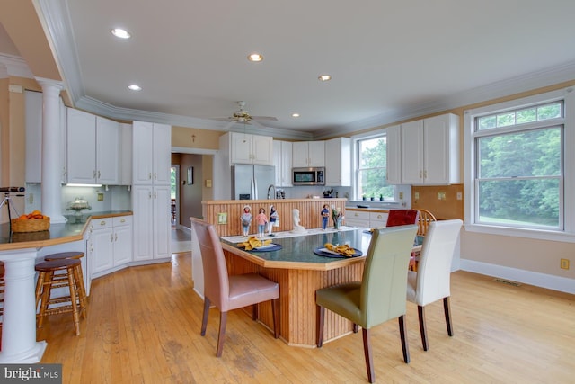 46369 Hattons Rest Ln, Lexington Park, MD 20653 - kitchen with stainless steel appliances, ornamental molding, white cabinetry, light wood finished floors, and a breakfast bar area