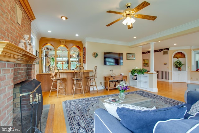 46369 Hattons Rest Ln, Lexington Park, MD 20653 - living room featuring decorative columns, ornamental molding, a brick fireplace, wood finished floors, and ceiling fan