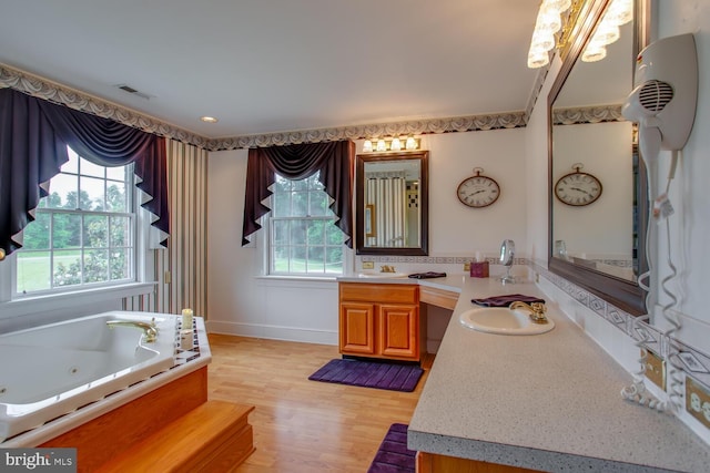 46369 Hattons Rest Ln, Lexington Park, MD 20653 - bathroom featuring vanity, a tub with jets, wood finished floors, and baseboards