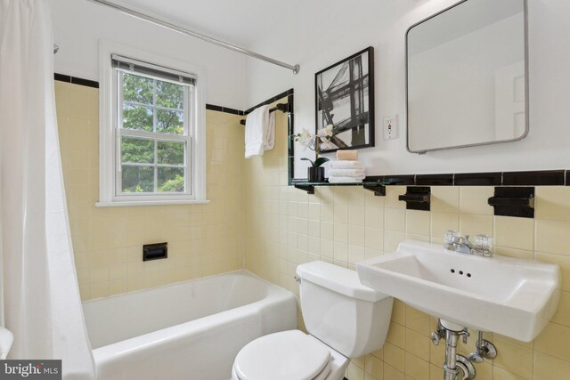 1725 Oakcrest Dr, Alexandria, VA 22302 - bathroom featuring tile walls, toilet, a sink, and shower / bath combo