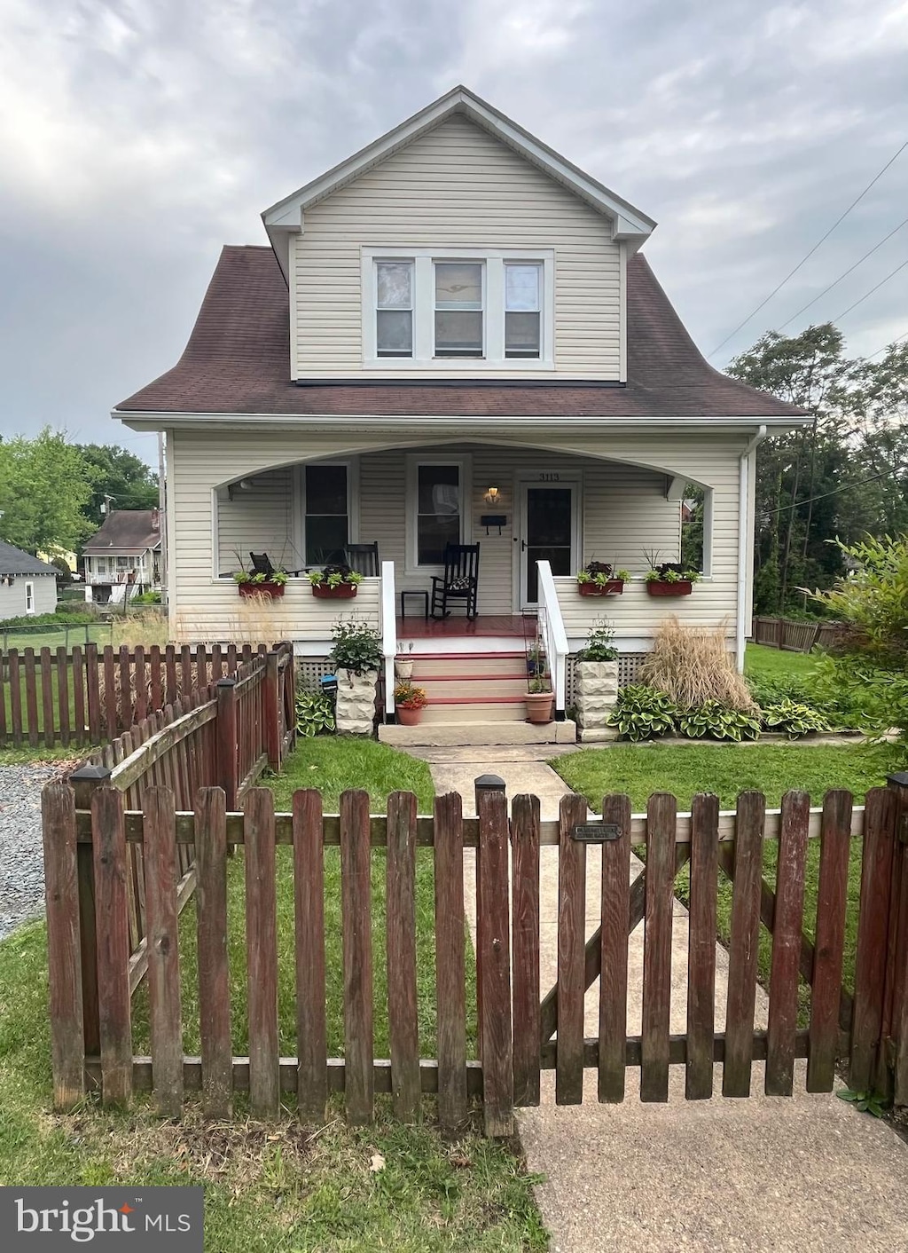 view of front facade featuring covered porch and a fenced front yard