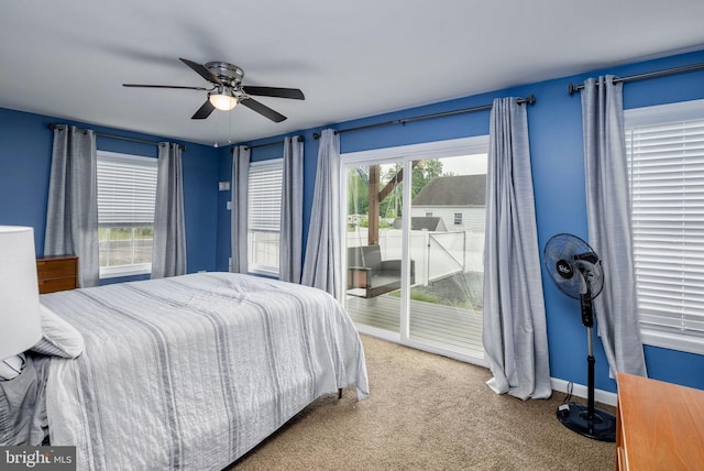 carpeted bedroom with access to outside, a ceiling fan, and baseboards