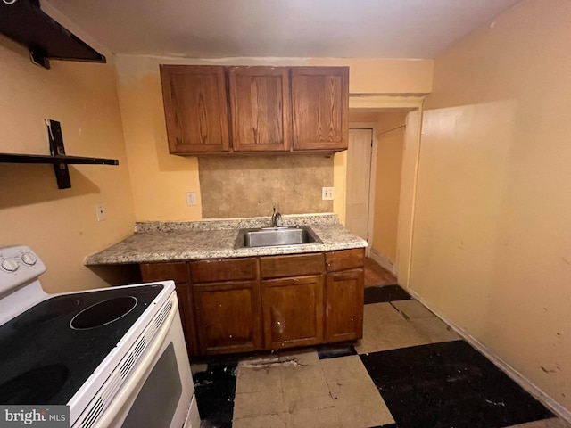2412 N Corlies St, Philadelphia, PA 19132 - kitchen featuring white range with electric stovetop, a sink, brown cabinets, and light countertops