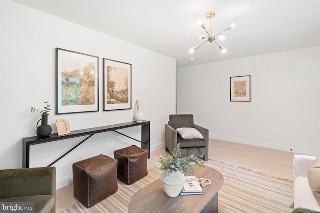 living room featuring a chandelier, light wood-type flooring, and baseboards