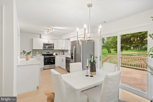 dining space featuring a chandelier and light wood finished floors