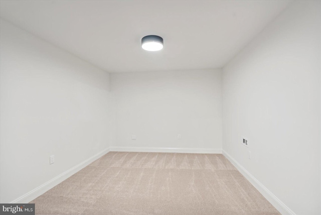 unfurnished room with light colored carpet and baseboards