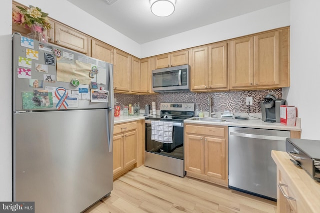 275 Green St Unit 4-I6, Edgewater Park, NJ 08010 - kitchen featuring appliances with stainless steel finishes, a sink, light wood finished floors, and decorative backsplash