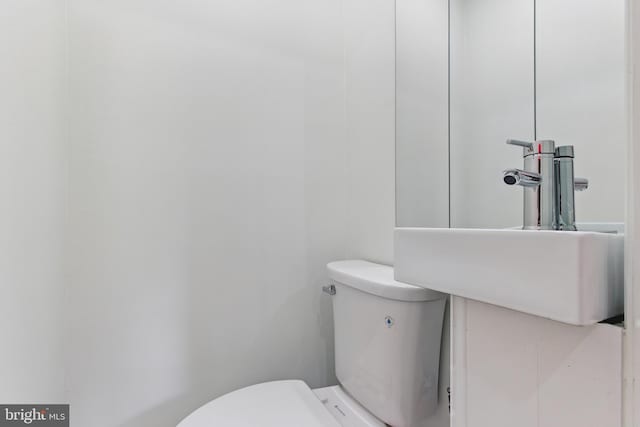 half bath featuring toilet and a sink